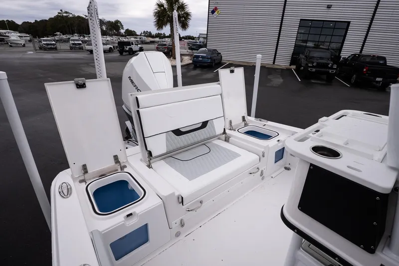 Slide: The Image of 2026 Blackfin 242 HB boat interior with seating, storage, and Mercury engine in a dealership lot. - 10