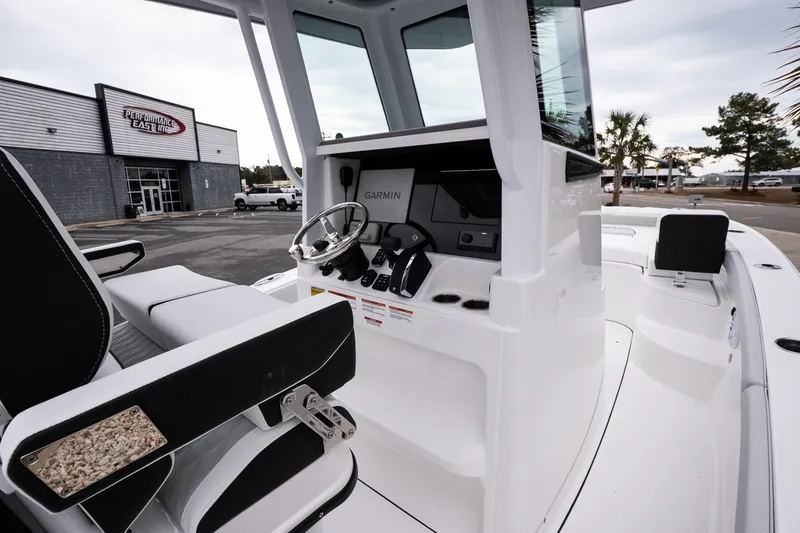 Slide: The Image of 2026 Blackfin 242 HB boat interior with modern controls and seating at a dealership. - 14