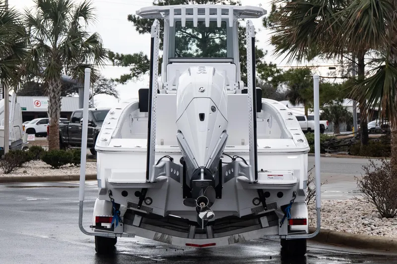 Slide: The Image of 2026 Blackfin 242 HB boat rear view with outboard motor, parked near palm trees. - 5