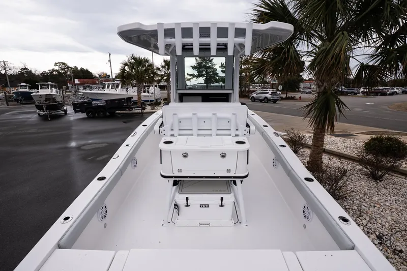 Slide: The Image of 2026 Blackfin 242 HB boat, sleek design, docked near palm trees and other boats. - 7