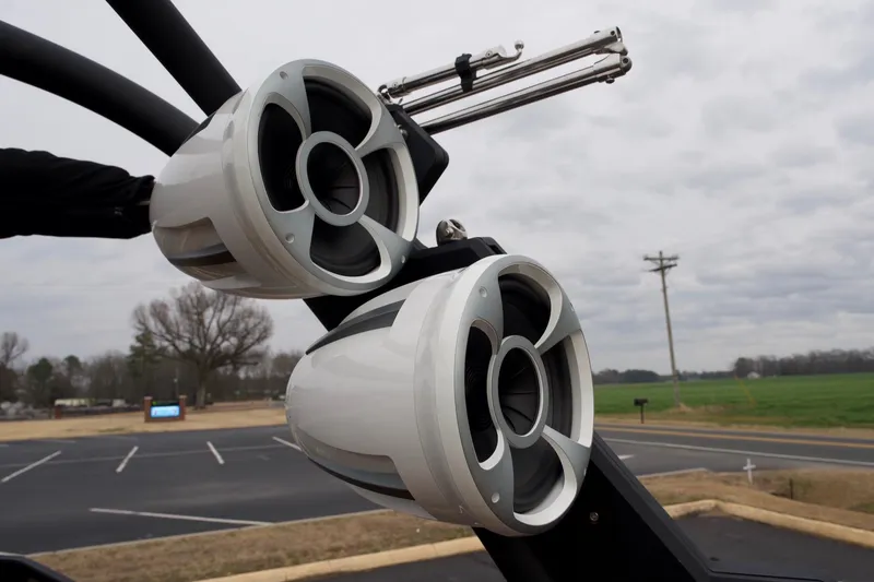 Slide: The Image of 2020 Malibu Wakesetter 24 MXZ boat speakers, mounted on a tower, with a cloudy sky background. - 14