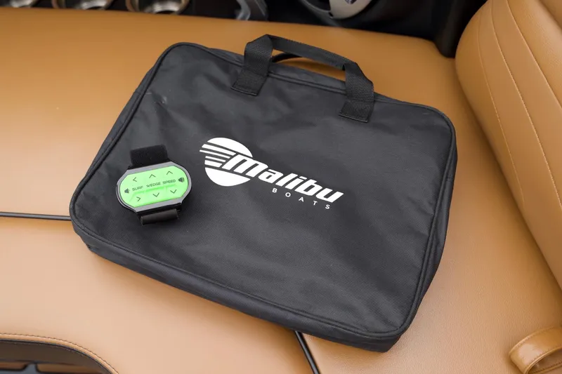 Slide: The Image of Malibu Wakesetter 24 MXZ 2020 bag and control device on tan boat seat. - 15