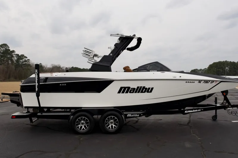Slide: The Image of 2020 Malibu Wakesetter 24 MXZ boat on trailer, side view, outdoors. - 2