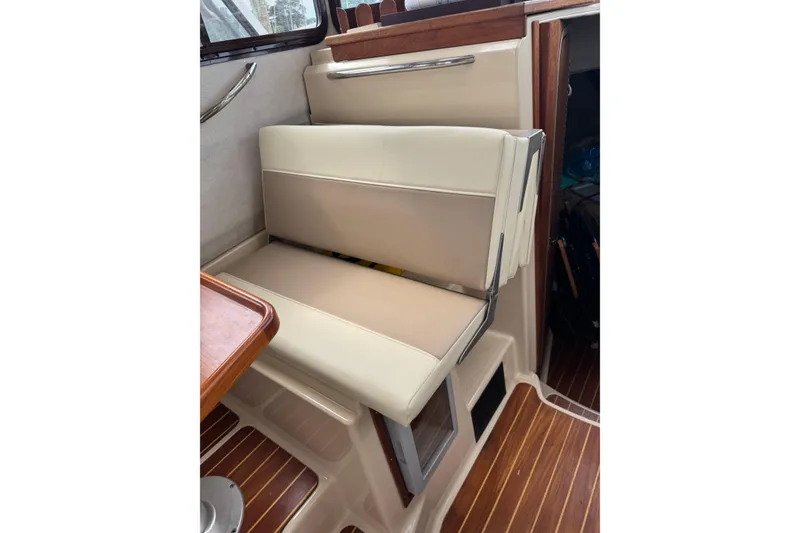 Slide: The Image of 2009 Ranger Tugs R-29 interior seating with beige upholstery and wooden accents. - 13