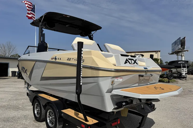 Slide: The Image of 2026 ATX Surf Boats 22 Type-S on trailer, featuring sleek design and American flag backdrop. - 2