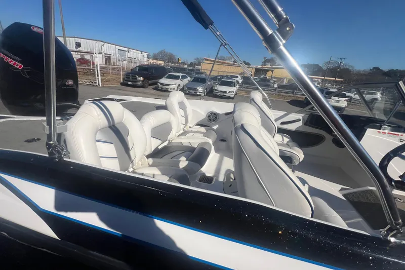 Slide: The Image of 2022 Nitro Z19 Sport boat with white interior, parked outdoors under clear blue sky. - 18