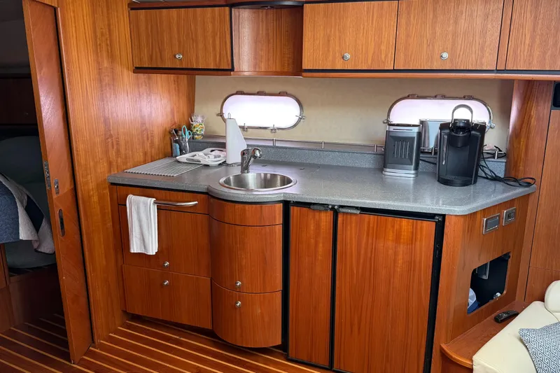 Slide: The Image of 2007 Tiara Yachts 3900 Sovran interior kitchen with wooden cabinets and modern appliances. - 38