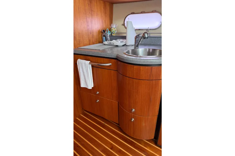 Slide: The Image of 2007 Tiara Yachts 3900 Sovran galley with wood cabinetry and stainless steel sink. - 39