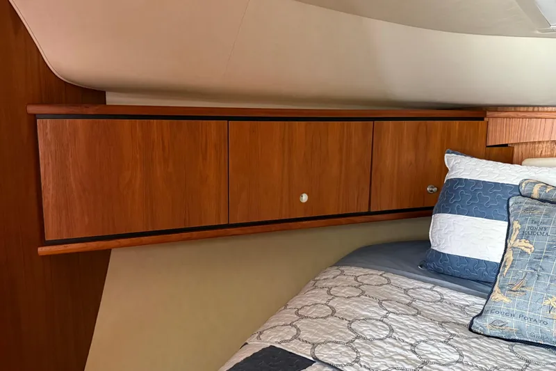 Slide: The Image of Interior of 2007 Tiara Yachts 3900 Sovran with wooden cabinets and cozy bedding. - 45