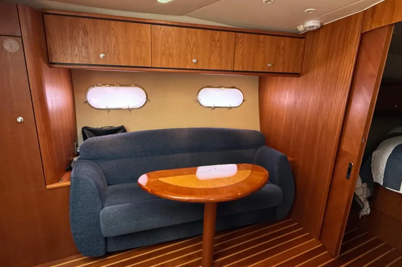 Slide: The Image of 2007 Tiara Yachts 3900 Sovran interior with blue sofa and wooden table. - 47