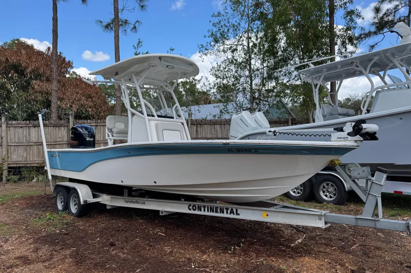 Slide: The Image of 2019 Sea Fox 240 Viper boat on trailer, parked outdoors with trees in background. - 1