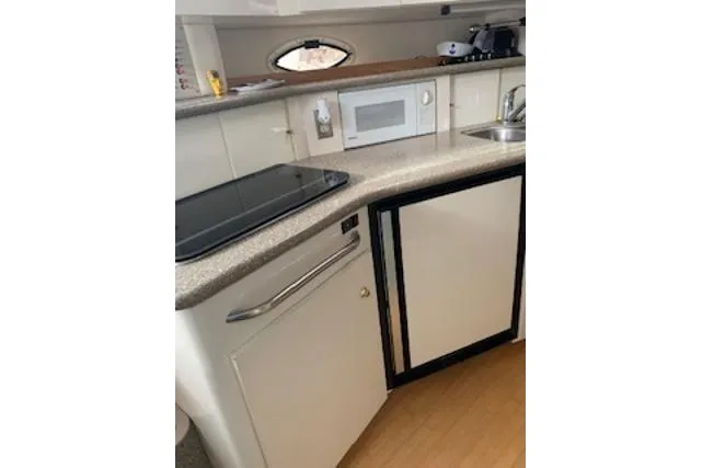 Slide: The Image of 2000 Maxum 3300 SCR yacht kitchen with stove, microwave, and sink. - 10