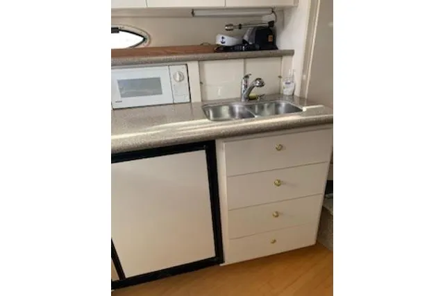 Slide: The Image of 2000 Maxum 3300 SCR yacht kitchen with sink, microwave, and storage drawers. - 11
