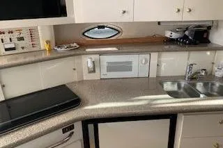 Slide: The Image of 2000 Maxum 3300 SCR yacht kitchen with modern appliances and sleek countertops. - 12