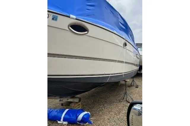 Slide: The Image of 2000 Maxum 3300 SCR boat with blue cover, stored on stands. - 26