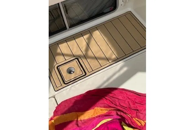 Slide: The Image of Maxum 3300 SCR 2000 boat deck with colorful towel and wooden flooring. - 29