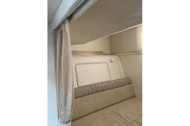 Slide: The Image of Interior cabin of 2000 Maxum 3300 SCR boat with beige upholstery and curtains. - 7