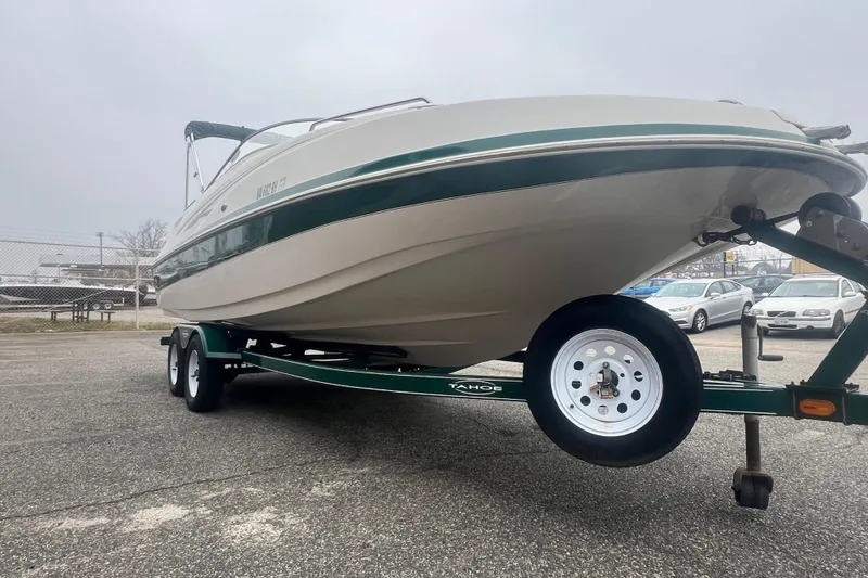 Slide: The Image of 2005 Tahoe 234 boat on trailer in parking lot, overcast sky. - 10