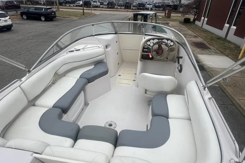 Slide: The Image of 2005 Tahoe 234 boat interior with white and gray seating, steering wheel, and dashboard. - 12