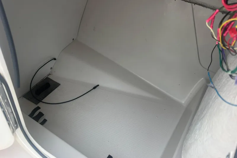 Slide: The Image of Interior of a 2005 Tahoe 234 boat showing wiring and storage compartment. - 16