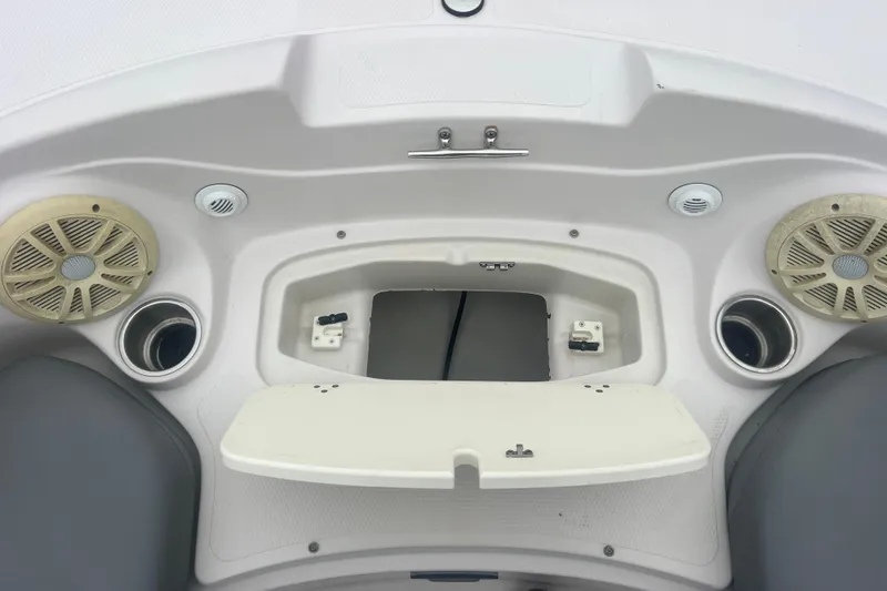 Slide: The Image of 2005 Tahoe 234 boat interior with speakers, cup holders, and storage compartment. - 22