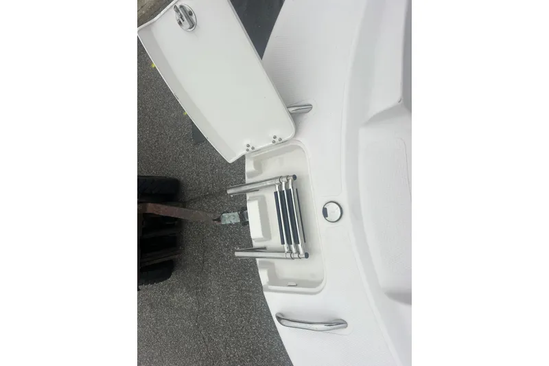 Slide: The Image of 2005 Tahoe 234 boat with folded swim ladder on deck. - 23