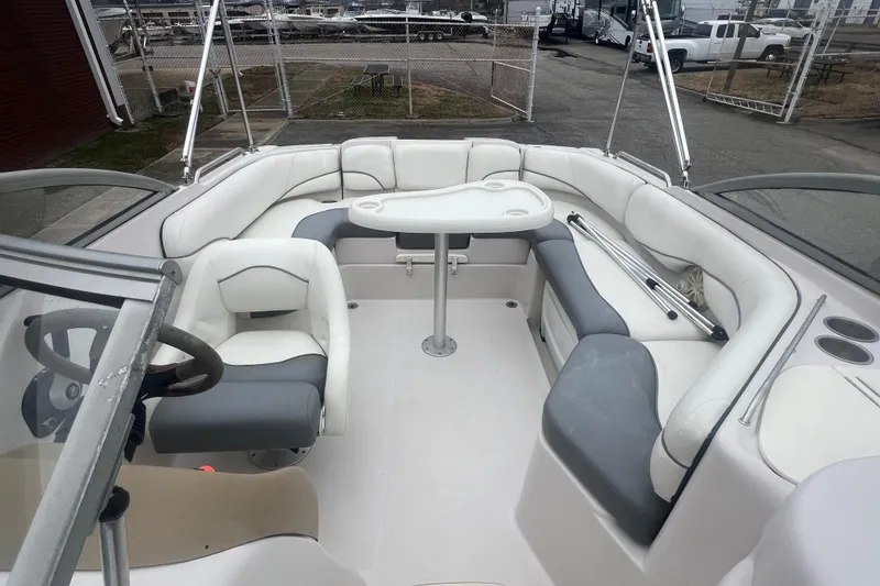 Slide: The Image of 2005 Tahoe 234 boat interior with white seating and steering wheel. - 26
