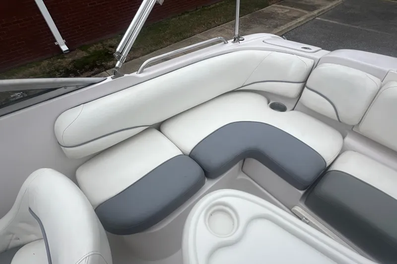 Slide: The Image of Interior seating of a 2005 Tahoe 234 boat, featuring white and gray upholstery. - 28