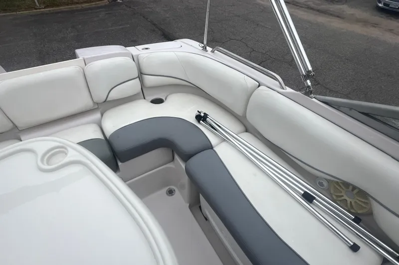 Slide: The Image of 2005 Tahoe 234 boat interior with white and gray seating, metal poles, and cup holder. - 30