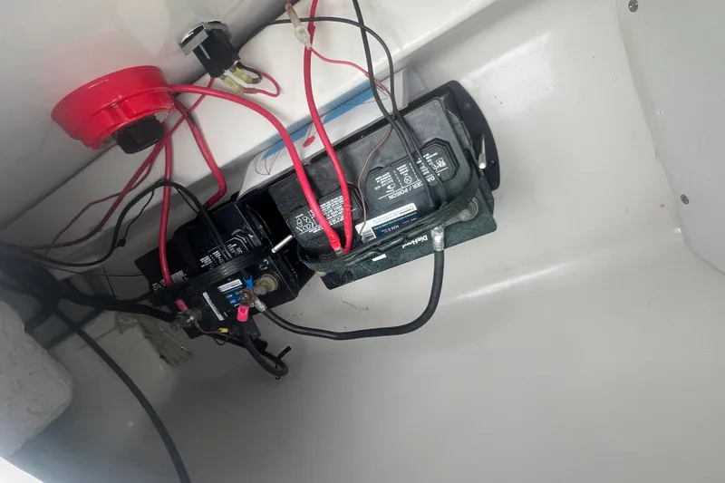 Slide: The Image of 2005 Tahoe 234 boat battery compartment with wiring and connections. - 31