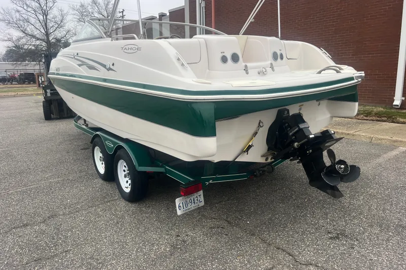 Slide: The Image of 2005 Tahoe 234 boat on trailer, green and white design, parked outdoors. - 4