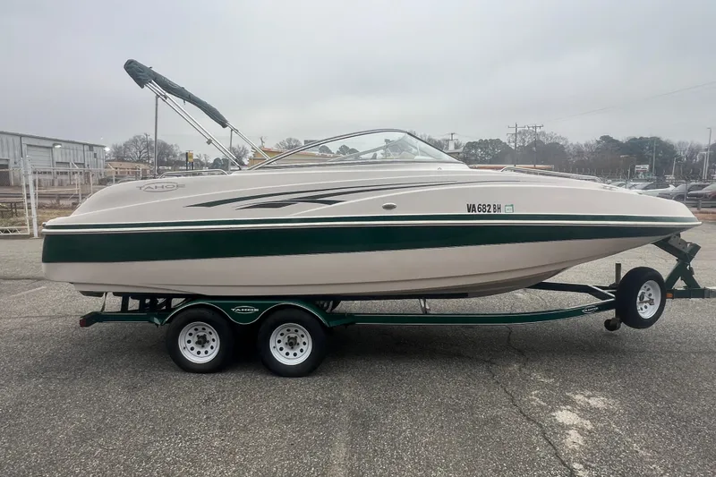 Slide: The Image of 2005 Tahoe 234 boat on trailer, white and green, parked outdoors. - 8