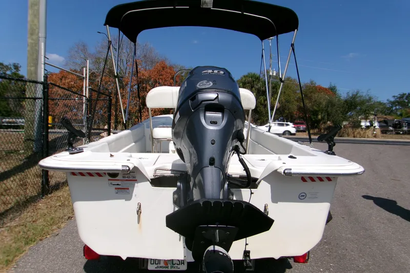 Slide: The Image of 2012 Carolina Skiff JVX16CC boat with outboard motor and canopy, parked on a sunny day. - 11