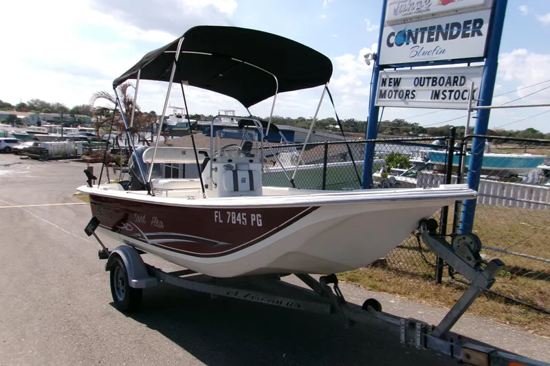 Slide: The Image of 2012 Carolina Skiff JVX16CC boat on trailer, parked near dealership sign. - 9