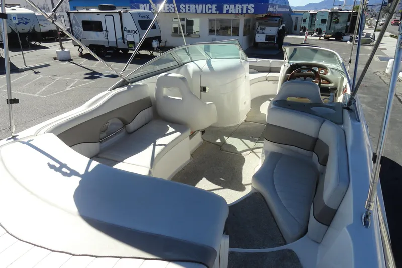 Slide: The Image of 2005 Kayot S245 boat interior with spacious seating and modern design in a dealership lot. - 15