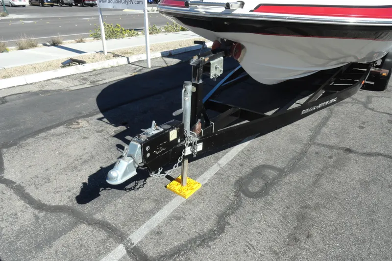 Slide: The Image of Trailer hitch of a 2005 Kayot S245 boat parked on asphalt. - 26