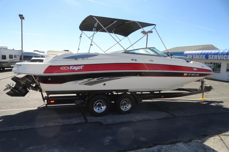 Slide: The Image of 2005 Kayot S245 boat on trailer, parked outdoors near RV sales and service. - 5