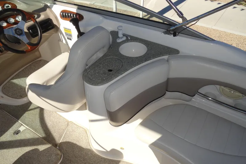 Slide: The Image of 2005 Kayot S245 boat interior with steering wheel, seating, and sink. - 8