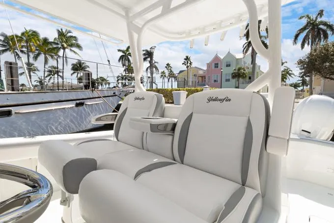 Slide: The Image of 2020 Yellowfin 39 Center Console boat with luxurious seating, palm trees, and colorful buildings in the background. - 6