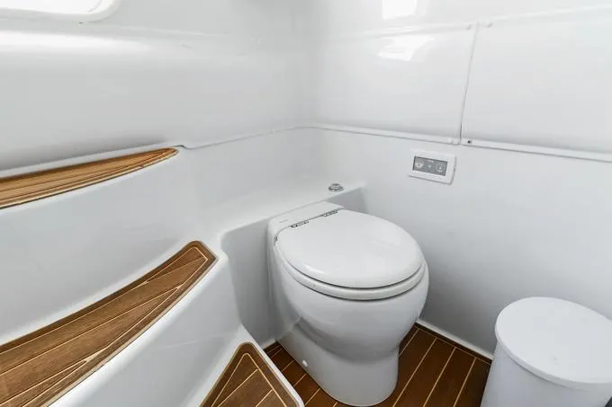 Slide: The Image of 2020 Yellowfin 39 Center Console boat bathroom with modern toilet and wooden flooring. - 9