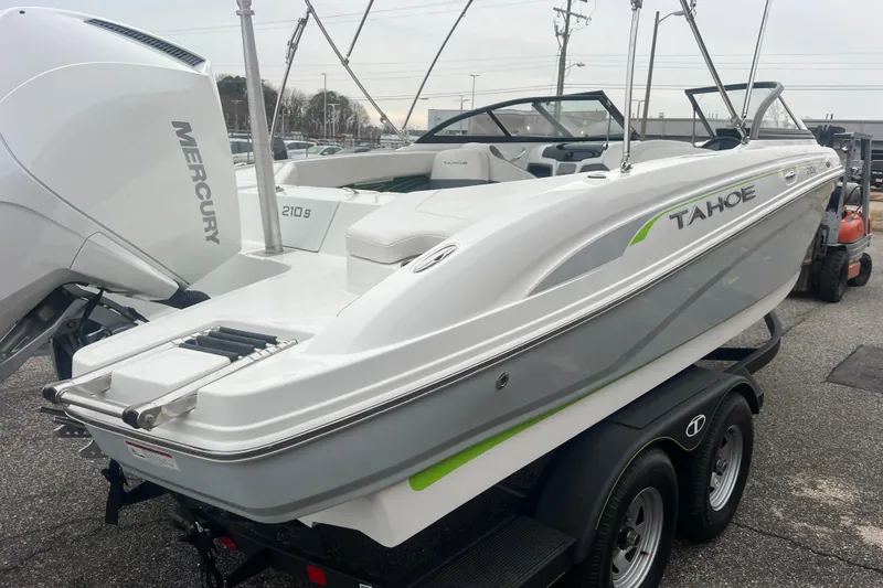 Slide: The Image of 2024 Tahoe 210 S boat on trailer with Mercury engine, parked outdoors. - 10