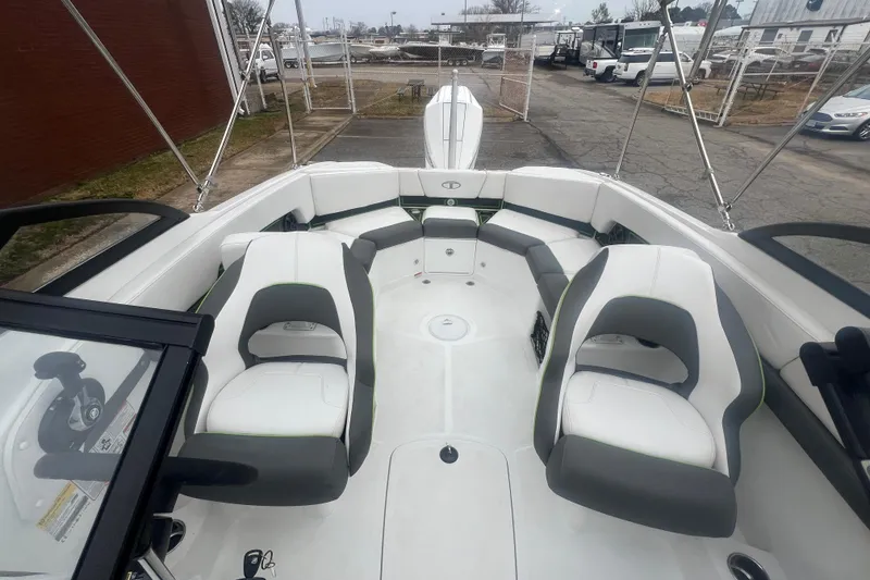 Slide: The Image of 2024 Tahoe 210 S boat interior with white and gray seating, docked outdoors. - 23