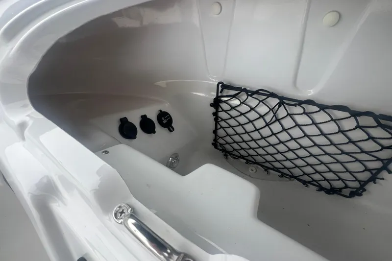 Slide: The Image of 2024 Tahoe 210 S boat storage compartment with netting and power outlets. - 26