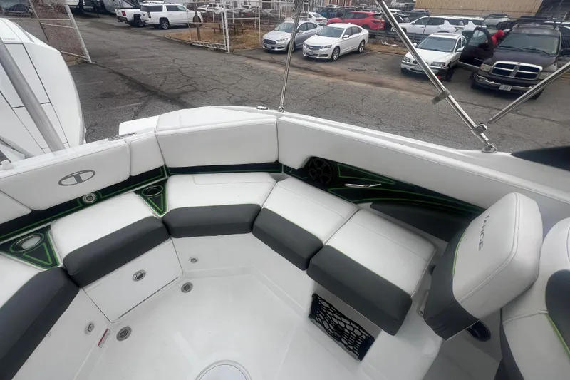 Slide: The Image of 2024 Tahoe 210 S boat interior with white and gray seating, parked in a lot. - 27