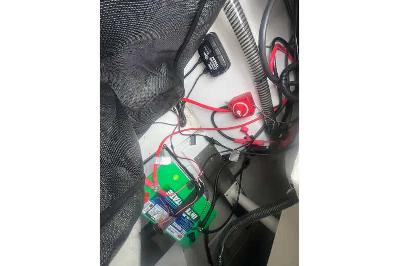 Slide: The Image of 2024 Tahoe 210 S boat battery compartment with wiring and components. - 31
