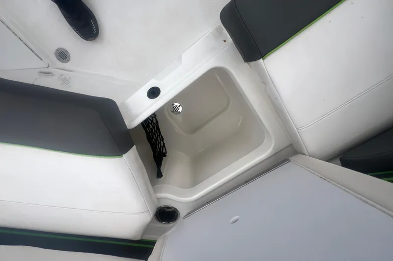 Slide: The Image of 2024 Tahoe 210 S boat interior storage compartment with seating and cup holder. - 34