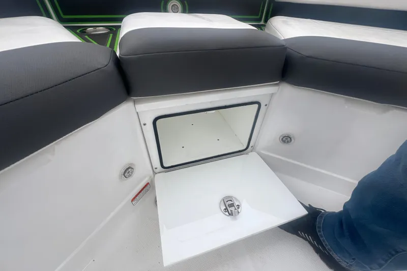 Slide: The Image of 2024 Tahoe 210 S boat interior storage compartment with cushioned seating. - 36