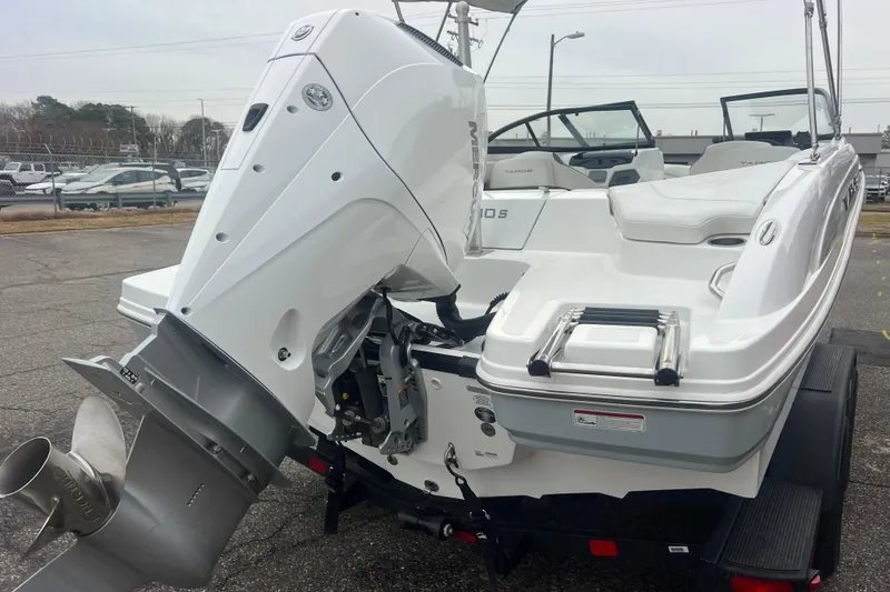 Slide: The Image of 2024 Tahoe 210 S boat with powerful outboard motor, parked on a trailer. - 8