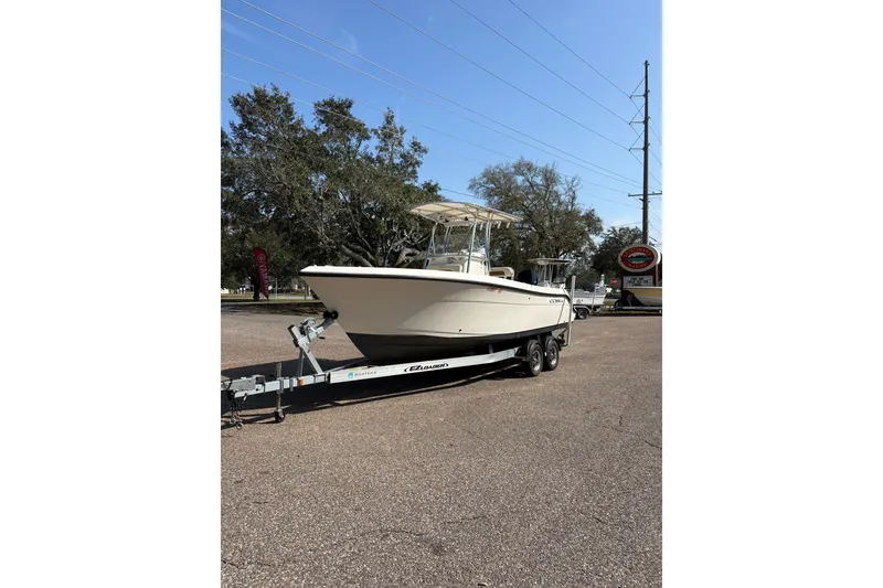 Slide: The Image of 2021 Cobia 237 Center Console boat on trailer, parked outdoors under clear sky. - 3