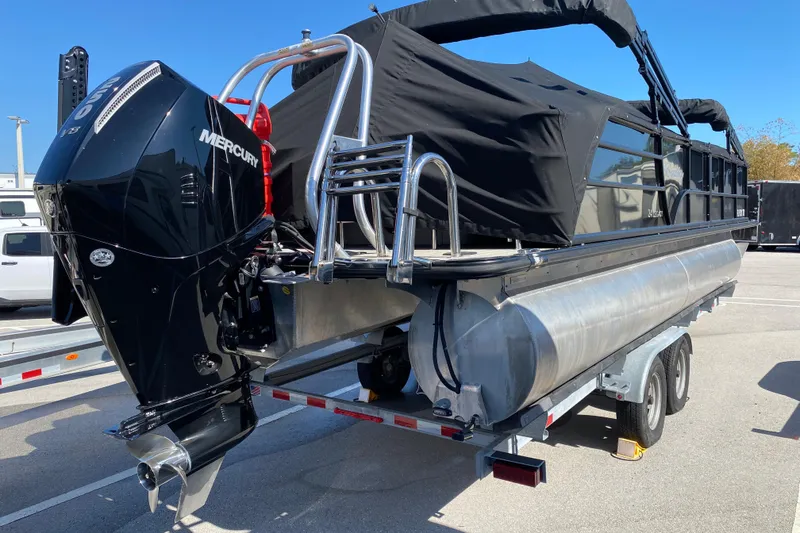 Slide: The Image of 2024 Bentley Pontoons Legacy Swingback with Mercury outboard engine on trailer. - 25